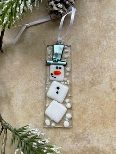 a snowman ornament hanging from a christmas tree