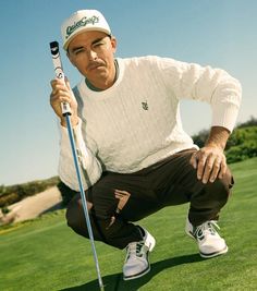 a man kneeling down holding a golf club