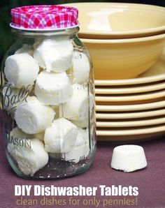 a jar filled with marshmallows sitting on top of a table next to plates