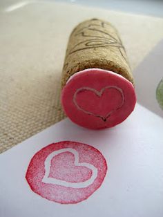 a heart stamp on a piece of paper next to a wine cork with the word love written in it