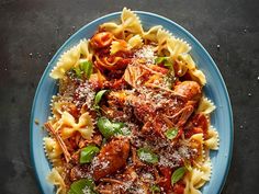 a blue plate topped with pasta and meat covered in sauce