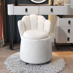 a white chair sitting on top of a rug in front of a mirror and dresser