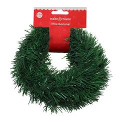 a green christmas wreath with red ribbon on it's end and an ad for make - or - decorate pine garland