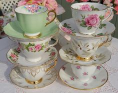 a stack of tea cups and saucers sitting on top of a table