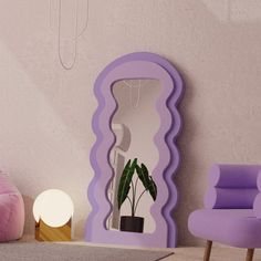 a purple mirror sitting on top of a floor next to a pink chair