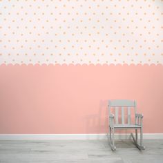 a white rocking chair against a pink wall with polka dot pattern on the walls and floor