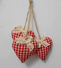 two red and white checkered hearts hanging from twine with burlocks on them