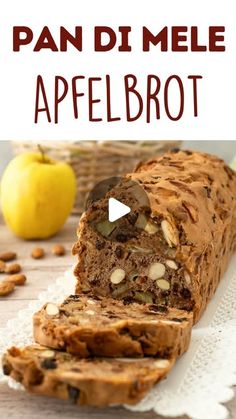 a loaf of bread sitting on top of a table next to an apple and nuts