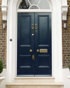 a blue front door with two potted plants