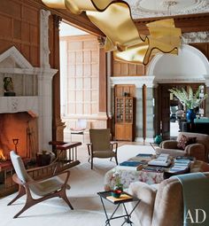 a living room filled with furniture and a fire place in the middle of it's walls