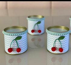 three tins with cherries painted on them