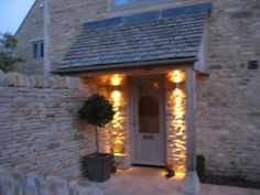 a stone building with lights on the front door