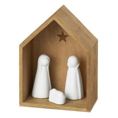 two white ceramic figurines in a wooden box with a star on the top