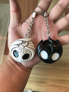 two black and white key chains in the palm of someone's hand