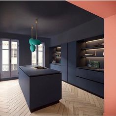 an empty kitchen with blue walls and wooden flooring is pictured in this image, there are two lamps hanging from the ceiling