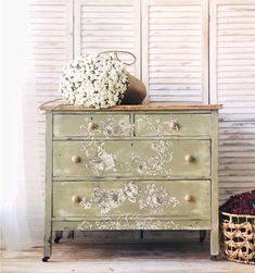 an old dresser with flowers on top and a basket full of baby's breath