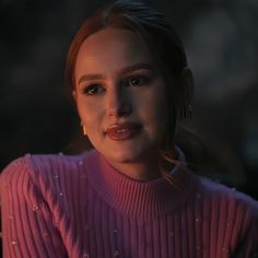 a close up of a person in a pink sweater