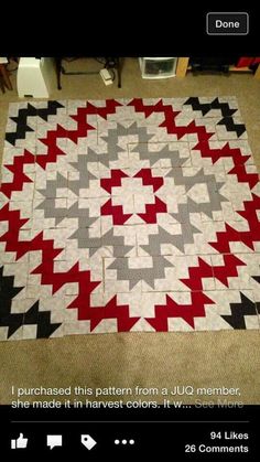 a red, white and black quilt on the floor