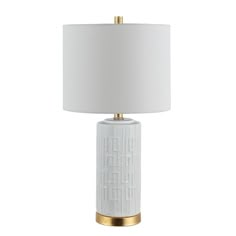 a white and gold table lamp with a white shade on the top, in front of a white background