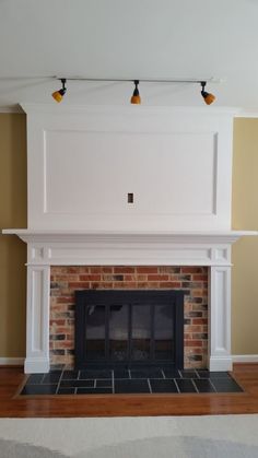 an image of a fireplace in the middle of a room with two lights on it