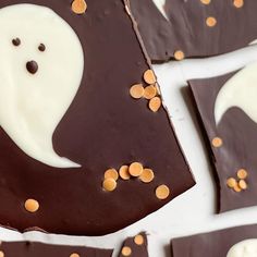 chocolate pieces with white frosting and sprinkles on them, arranged in the shape of a ghost