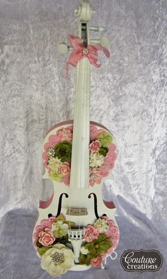 a white violin with pink flowers on it