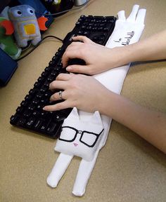 a person is typing on a computer keyboard with glasses on their head and hands resting on the keyboard