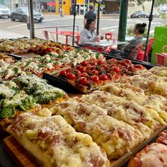 many different types of pizzas are on display