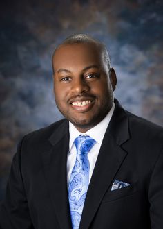 a man in a black suit and blue tie