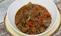 a white bowl filled with beef and peppers