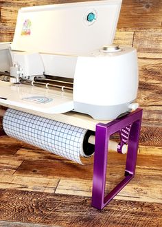 a white and purple machine sitting on top of a wooden floor