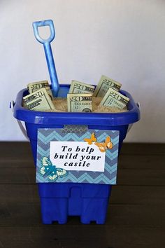 a plastic container with money in it and a blue shovel sticking out of the top