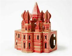 a paper model of a castle made out of red and tan cardboards on a white background