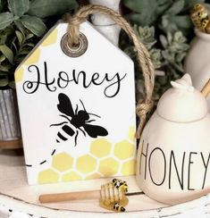 a honey jar with some bees on it and a sign that says honey next to it