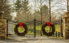 two wreaths are on the gate to a driveway