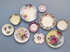 a collection of porcelain plates and saucers with flowers on them, all decorated in different colors