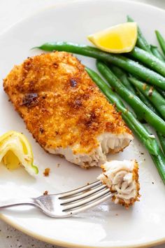 a white plate topped with fish and green beans