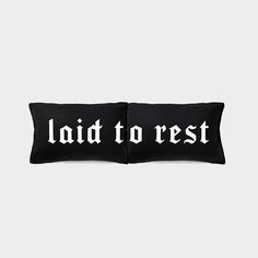 two black pillows with the words laid to rest on them