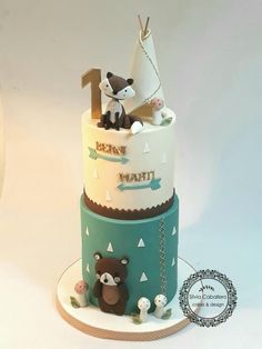 a three tiered cake decorated with animals and letters on it's sides, sitting on a plate