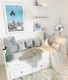 a living room filled with lots of furniture and pillows on top of a white couch