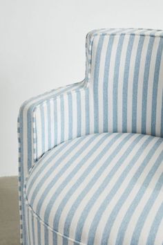 a blue and white striped chair sitting on top of a hard wood floor