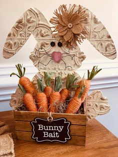 a wooden box filled with carrots sitting on top of a table next to a sign