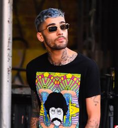 a man with grey hair and tattoos wearing a t - shirt