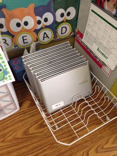 a desktop computer sitting on top of a metal shelf next to a binder rack