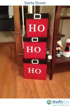 a stack of red boxes sitting on top of a wooden floor next to a christmas tree