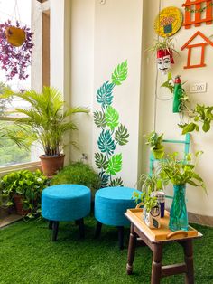 a room with green grass and blue stools on the floor next to potted plants