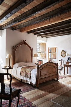 a bed room with a neatly made bed and wooden furniture