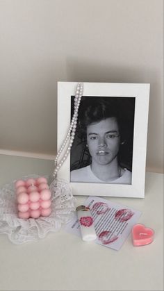 a photo and some pink beads on a white table next to a heart shaped bead necklace