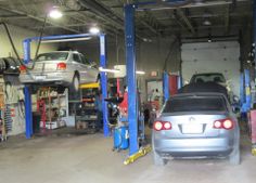 a car is parked in a garage with other cars on the rack and around it