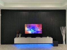 a large flat screen tv sitting on top of a white entertainment center in a living room